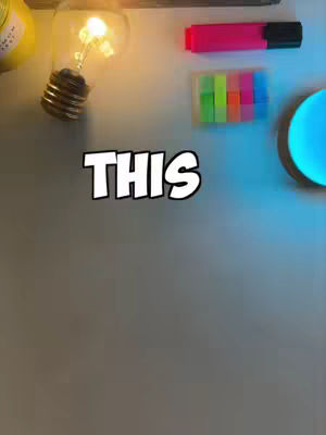 The cover image is an overhead shot featuring a light-colored, possibly gray surface. A light bulb, lit and emitting a warm, golden glow, is positioned on the left. To the right, there's a stack of colorful sticky notes, and a red highlighter, while the focus is on “THIS” written in a bold, white, outlined font, centered on the frame. The scene has a modern, clean aesthetic with the light providing a focal point.