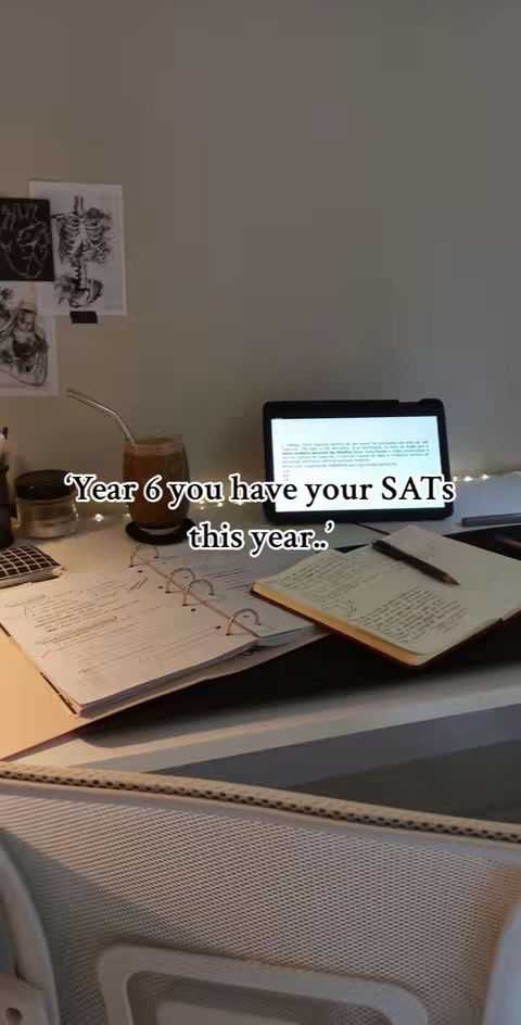 A well-lit, slightly cluttered desk setting with study materials. A small glass with drink, open notebook, and a tablet. Printed anatomy images are tacked to the wall. Text overlay at the center.