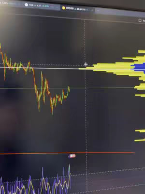 A computer screen displaying a stock chart with candlestick and volume indicator and other technical analysis overlaid. The background is dark, and the chart data has color-coded indications. The screen is the primary focus and the overall composition is technical and data-driven.