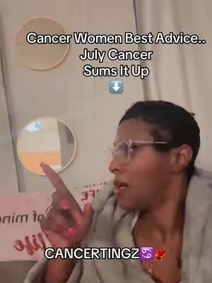 A woman with short black hair and glasses, wearing a gray top, is pointing to the left with her right index finger. She is positioned in front of a white wall with two round mirrors. Text overlays and a zodiac symbol add context.