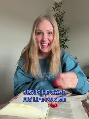 A woman is sitting in front of an opened book with the text overlayed on the bottom. She looks surprised, with her mouth wide open, and is pointing with her right hand. She has long blonde hair and is wearing a teal sweatshirt.