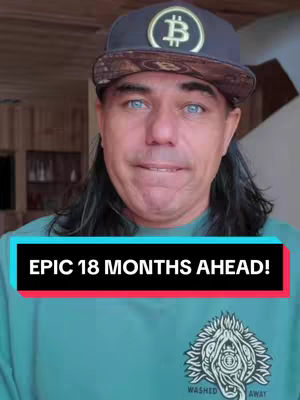 A middle-aged man wearing a baseball cap with a Bitcoin symbol and a blue t-shirt looks at the camera in a medium shot. A colorful overlay with the text "EPIC 18 MONTHS AHEAD!" is placed at the bottom of the frame.