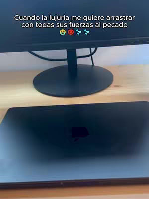 The cover image presents a top-down view of a workspace scene. A black computer monitor dominates the upper half of the frame, supported by a stand. Below it, a closed black laptop sits on a wooden surface. The scene is simply lit.