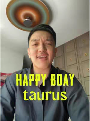 The cover image shows a man smiling and looking at the camera. The man is wearing a dark shirt. Colored text overlayed reads "HAPPY BDAY taurus". Behind the man is a wall with some rectangular panels and a ceiling with a circular design with a light fixture.