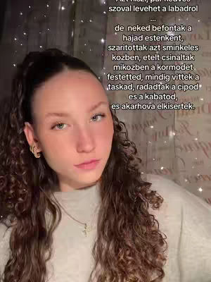 A young woman with long, wavy brown hair and fair skin is centered in the frame, looking directly at the camera with a slight, calm expression. She wears small hoop earrings and a simple necklace. A light-colored top covers her shoulders. The background has a textured appearance with subtle, glittering lights. Text overlays are present on the right side of the image, with the top portion of the text nearly at the top and the remainder descending down the right-hand side.