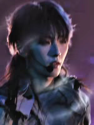 The cover image shows a close-up shot of a person, possibly a performer, with a microphone headset. The lighting is dramatic, with cool tones washing over the face illuminated from the front. The background is blurred, suggesting a stage or concert setting, with purple and blue hues. The person appears to be mid-performance; their expression and pose suggest a performance, or a moment captured during a live event. The focus is tight on their face, highlighting their features and expression.