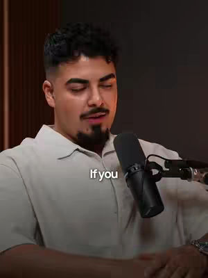 A man with dark hair and a goatee is speaking into a microphone. Text overlayed on the image reads, "If you". The background appears to be a dark wall.