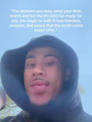 A selfie-style shot features a young man wearing a dark hoodie, set against what appears to be a softly lit, cloudy background. The man, framed from the chest up, has a neutral expression. White text is overlaid at the top of the image, containing a motivational quote.