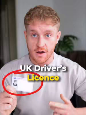 A man with short, light brown hair and a light gray t-shirt is looking directly at the camera with an open mouth expression. Overlayed text says "UK Driver's Licence" in large, bold, white letters. The words are positioned above a red circle highlighting a driver's license held in his left hand.
