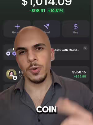 A man with a bald head is in selfie mode and is talking while pointing at a phone screen that displays financial information. There are two text boxes in the lower part of the image that display the word COIN.