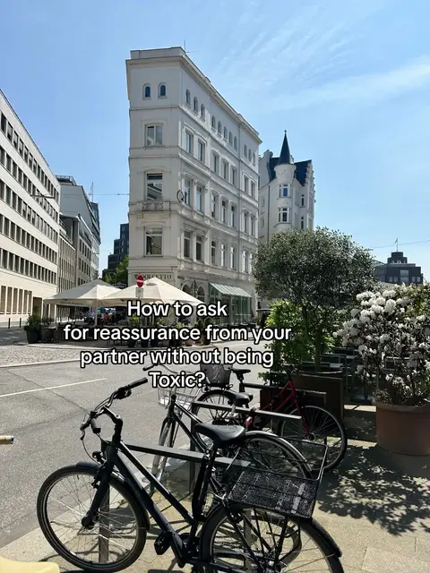 A sunny cityscape features a tall, white building with a unique angled design, bicycles parked in the foreground, and text overlayed. The image is bright and the composition is clean.