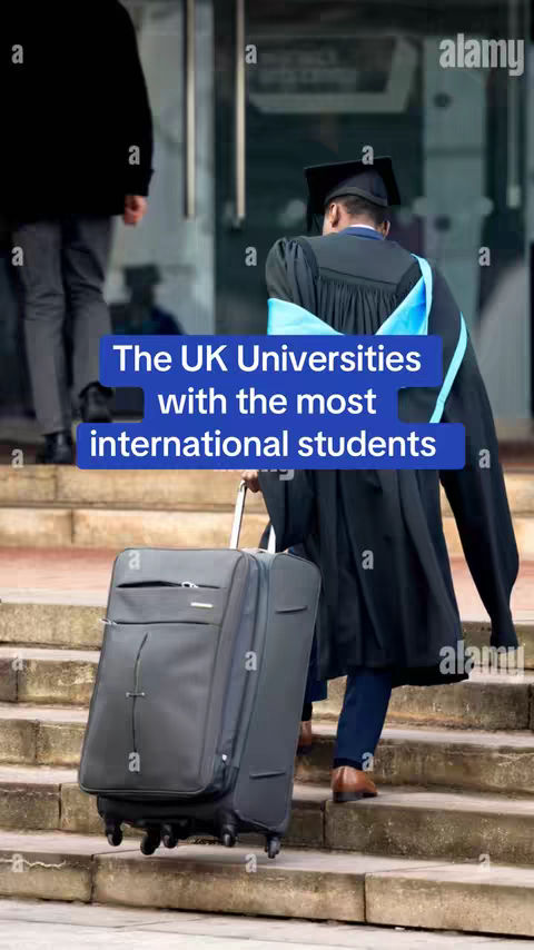 A man wearing a graduation gown and hat with a blue sash is walking up a set of stone steps while pulling a rolling suitcase. A person in dark clothes is walking away in the background. The text overlay reads: The UK Universities with the most international students.