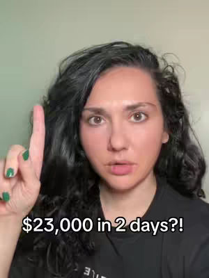 A woman with dark curly hair and fair skin points upwards with her right index finger. Overlayed text states "$23,000 in 2 days?!"