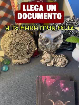 The image shows a collection of objects on a gray surface. On the left is a stone carving of a round object with a circular design, and on its right is a silver owl figurine. Below the owl is a small, skeletal animal figurine. In the lower right corner, a stack of tarot cards is visible. A red banner at the top reads the text over the objects.