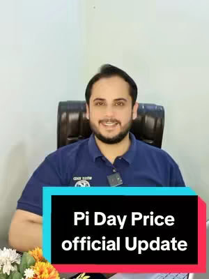 A man in a blue polo shirt smiles and looks directly at the camera. Behind him is a black office chair and a plain wall. A text overlay in a rectangular box at the bottom states "Pi Day Price official Update". There are some flowers in the corner