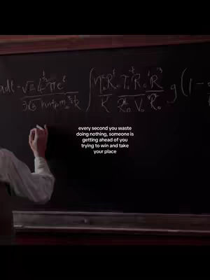 A chalkboard filled with complex mathematical formulas. The hand of a person in a white shirt is seen writing on the board. A text overlay reads: 'every second you waste doing nothing, someone is getting ahead of you trying to win and take your place'.