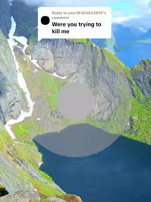A landscape with a mountain and a lake. The image has a white rectangle with text. A gray blurred circle is present on the mountains.
