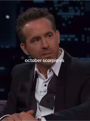 The cover image features a medium shot of Ryan Reynolds, seen from the chest up. He is wearing a dark suit jacket over a white shirt and a black bow tie. The background appears to be a studio or interview setting. Overlayed on the image towards the bottom is the text 'october scorpio vs'.