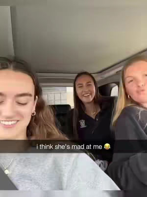 Three young women are inside a car, with two in the front and one in the backseat. The woman on the left is smiling and turned towards the camera. The hook is a text at the bottom that says, "i think she's mad at me". The composition is a selfie style shot.