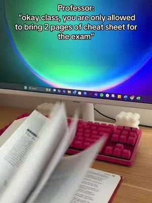 A person's workspace is shown with a monitor displaying a colorful background, a keyboard with red keycaps, and open books being flipped through. The top part of the screen overlays a message with the text overlayed onto this image.