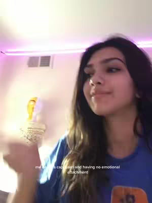 The cover photo shows a young woman in a blue t-shirt, with long dark hair. She is looking slightly away from the center of the frame, and seems to be holding something off-camera. The background has a soft, ambient lighting, potentially from a neon or colored light source.