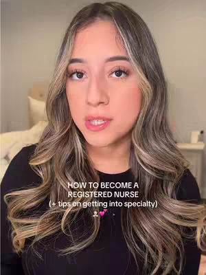 A woman with long, wavy, brown and blonde hair is centered in a selfie-style shot. She has a fair complexion, wearing a black top. The background is blurred but hints at a bedroom setting. The text overlayed reads 'HOW TO BECOME A REGISTERED NURSE (+ tips on getting into specialty)'