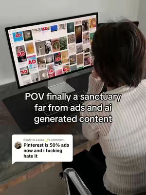 A person is seen from the back, sitting at a desk with a large computer monitor displaying images, presumably the Pinterest interface covered with ads. Text overlayed on the image reads, 'POV finally a sanctuary far from ads and ai generated content.' In the bottom left corner, a comment bubble mentions the prevalence of ads on Pinterest.