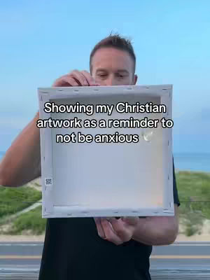 A man stands outdoors, holding a canvas; text overlays on the canvas.