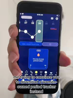 A person holds a smartphone displaying a period-tracking app, with the interface showing a graph, calendar dates, and prompts. Text overlays at the bottom suggest the app being advertised.