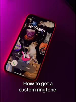 The cover image showcases a smartphone screen displaying a whimsical illustration and a call screen element. The background transitions from dark purple to pink, suggesting a gradient effect and the phone is angled, with the screen displaying an array of cosmic-themed images: cats floating in space alongside astronomical elements like stars, a drum, and a guitar. Text at the bottom reads, 'How to get a custom ringtone'.