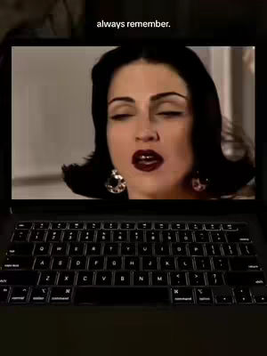 A woman with dark hair and dark lipstick is seen on a laptop screen. The laptop is on a black surface, and the screen is lit. Above the screen is the text "always remember."
