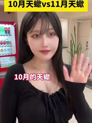 The cover image features a woman with long black hair and bangs, looking directly at the camera. She's wearing a black top and has her hand up as if waving. The background includes a red vending machine and other indistinct elements, and has text overlays in both the top and bottom of the frame.