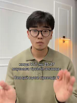 A man with dark hair and glasses looks directly at the camera, while a text overlay appears on the front of the image. The background is a simple white wall with a lamp visible on the right.