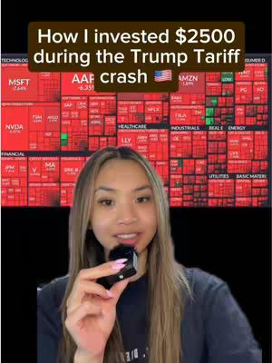 A woman is filming a video while holding a small microphone. Behind her is a visual representation of stock market data, which is red and displays numerous financial symbols and text. In the foreground, the woman has long brown hair and is wearing a dark shirt. The background stock market data has white fonts over red.