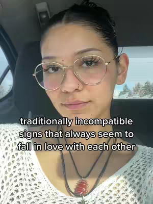 A selfie of a young woman in a car, facing forward and looking slightly to the side. She wears glasses and has her hair pulled back. Text is overlaid on the image.