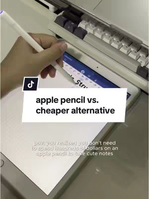 The cover image shows a hand holding a white stylus pen over a white iPad. The iPad is open to a notes app with text visible on the screen. The background includes a keyboard and a small section of a table. A black and white rectangle overlay is at the center with text.