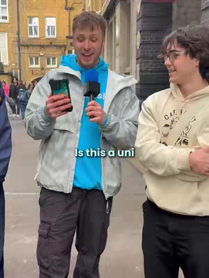 The cover image features a man holding a microphone and a phone, interviewing another man on the street. The scene is set outdoors with a building in the background, and the text overlay asks, "Is this a uni?"