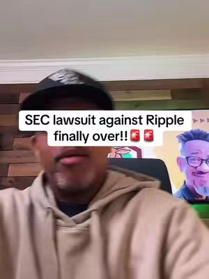 The cover image is a selfie-style shot featuring a man wearing a black cap and a tan hoodie. He is centered and looking towards the camera. Above him, a text overlay in a white box declares, 'SEC lawsuit against Ripple finally over!!' accompanied by two emoji: a flag and a sake cup. Behind him, a portion of a digital screen displays the image of another man with glasses. The background is blurred, with wooden paneling visible on the wall.