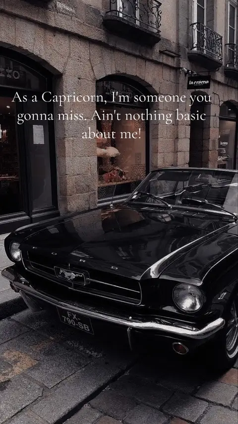 A black classic car is parked on a cobblestone street in front of a building with arched windows. Text is overlayed on the image.