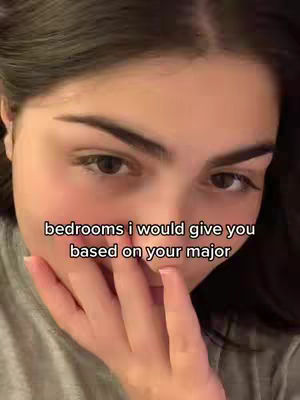 The cover image shows a close-up of a person's face, likely a young woman. She has dark hair, heavily emphasized eyebrows and visible eye makeup. She has fair skin, and a hand is partially covering her mouth. Overlayed text reads "bedrooms i would give you based on your major". The overall color palette is natural.