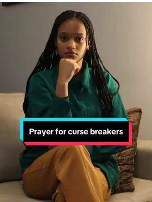 A young woman with long, braided hair is seated on a light-colored couch, resting her chin on her hand. She is wearing a dark green button-down shirt and tan pants. A text overlay in a teal and fuchsia box at the bottom of the image reads, "Prayer for curse breakers". The overall composition is balanced and the lighting appears soft.