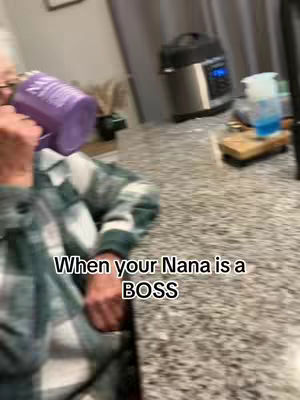 The cover image shows a person holding a purple container, obscured by the person's arm; the person appears to be in a kitchen, with appliances and items on the counter in the background. Text overlaid at the bottom reads 'When your Nana is a BOSS'.