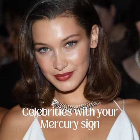 The cover image shows a close-up of a woman with brown hair, green eyes, and red lipstick. She is wearing a white top and a diamond necklace. The background is blurred but appears to be a dimly lit event. Text overlayed on the image reads, "Celebrities with your Mercury sign."