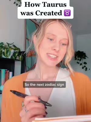 A woman with blonde hair is holding a pen and paper, seemingly mid-sentence. Above her is a text overlay, and behind her is a wall tapestry.