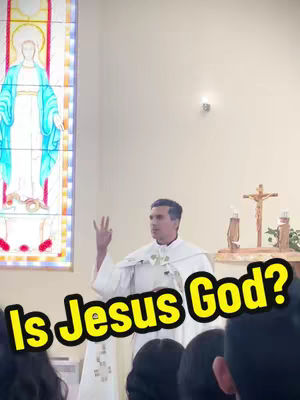A man in a white robe stands in a church, with a stained glass window of the Virgin Mary visible on the left. A yellow and black text overlay reads "Is Jesus God?". The man raises three fingers in a gesture.