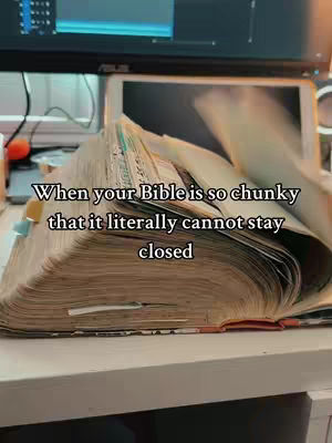 The cover image highlights an open Bible, focusing on its thick pages, which are slightly curved, suggesting it is well-used. Text overlays are featured, and the Bible is positioned on a white surface with a blurred background including a computer.