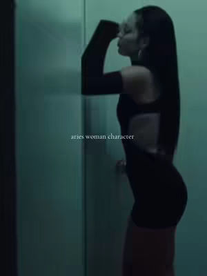 A woman in a black dress is leaning against a wall, with the text 'aries woman character' overlaid.
