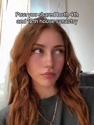 A young woman with long, wavy auburn hair gazes off to the right with a slightly pensive expression. Text overlay at the top reads, 'Pov: you shared both 4th and 12th house synastry.' She is wearing a dark top and a necklace. The background is blurred, suggesting a simple indoor setting.