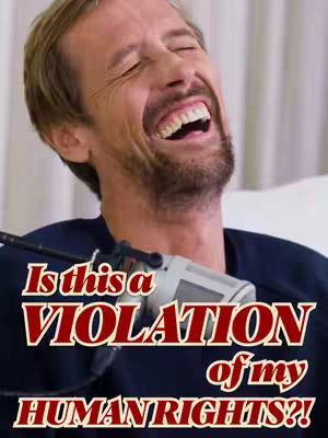 A man with short brown hair and a beard is laughing while holding a microphone. Text overlayed on the image reads "Is this a VIOLATION of my HUMAN RIGHTS?!"