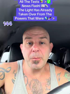 A man with a bald head and tattoos is centered in the frame, facing the camera. A text overlay in a purple box is at the top and the number 144 is on the left side. The background appears to be the interior of a car.